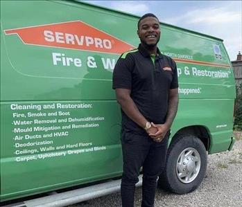 male employee standing in front of SERVPRO van